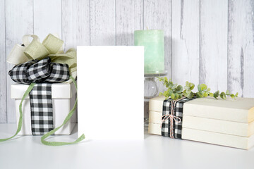 White blank greeting card. Farmhouse craft product mockup with farmhouse style decor, gifts and stack of books for Mother's Day, Father's Day, Birthdays, and Anniversaries. Negative copy space.