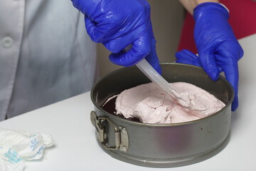 A woman prepares a marshmallow cake. Places a layer of jelly and marshmallows on the biscuit. Works...