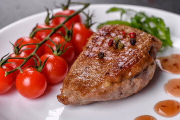 Baked duck breast with herbs and spices on a dark concrete background