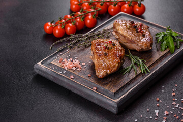 Baked duck breast with herbs and spices on a dark concrete background