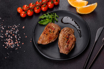 Baked duck breast with herbs and spices on a dark concrete background