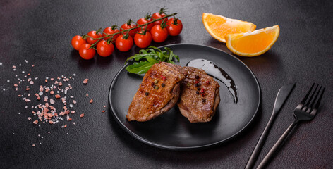 Baked duck breast with herbs and spices on a dark concrete background