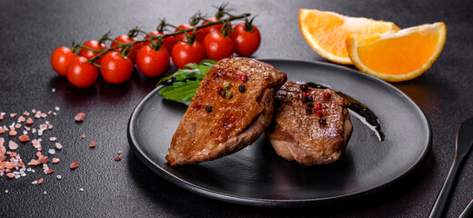 Baked duck breast with herbs and spices on a dark concrete background