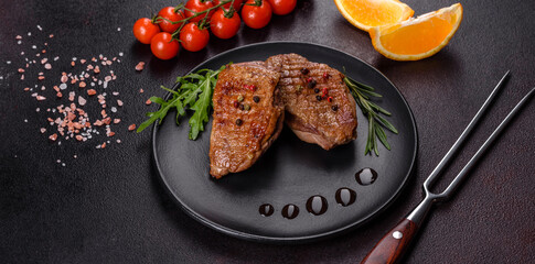 Baked duck breast with herbs and spices on a dark concrete background