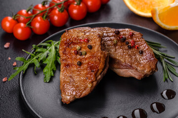 Baked duck breast with herbs and spices on a dark concrete background