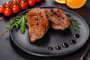 Baked duck breast with herbs and spices on a dark concrete background