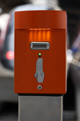 Orange ticket stamping machine at platform of main railway staton HB at City of Zurich. Photo taken April 27th, 2021, Zurich, Switzerland.