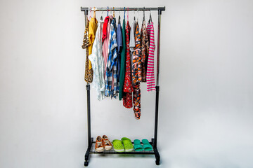 Different clothes and shoes from the wardrobe on the rack