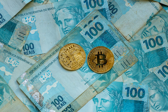 Notas de 100 reais e bitcoin