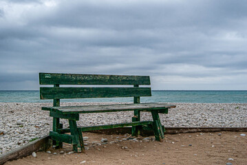 green wooden bench by the sea in Altea, Alicante, Spain.
