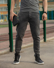 Young fashion man's legs with black sneakers. Black shoes