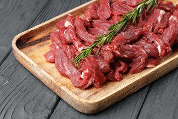 Raw sliced beef meat on wooden board