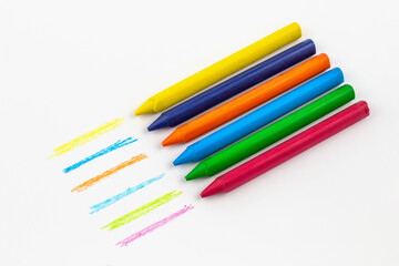 wax crayons in a row on white paper