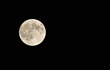 full moon in the early morning on a dark sky