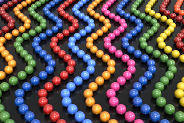 Background from multi-colored plastic beads on a transparent line. The beads are arranged in a vertical wave. Bijouterie. 3d illustration.
