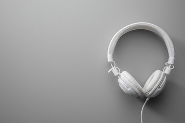 White wired stereo headphones on gray background.