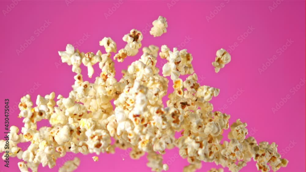 Poster Super slow motion popcorn flies on a pink background. Filmed on a high-speed camera at 1000 fps.High quality FullHD footage