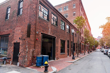 Renovated red-brick buildings along a tree lined street in a historic district in autumn. Seaport district, Boston, MA, USA.