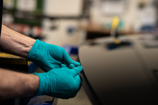 Worker With Gloves Assembling Rubber In Canopy Car Glass In Automotive Plant