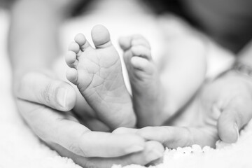 fotografía de stock de madre latinoamericana sosteniendo los pequeños pies de su bebe recién...