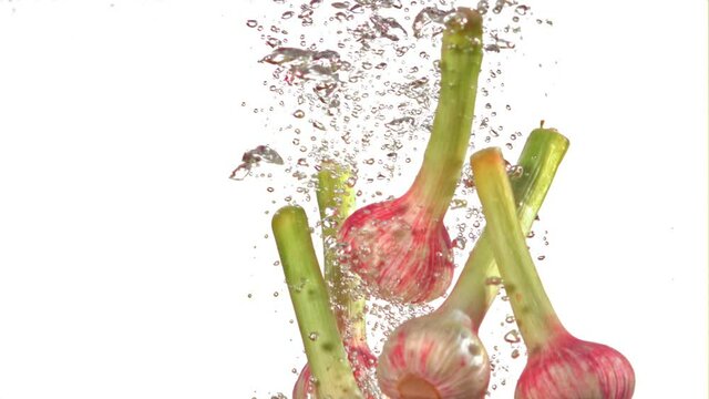 Super slow motion garlic under water with air bubbles on a white background. Filmed on a high-speed camera at 1000 fps. High quality FullHD footage
