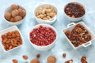 Assortment of different nuts, healthy natural food concept, almonds, pecans, pistachios, cashews, walnuts and pine nuts, high-calorie food with vegetable protein and vitamins, dietary nutrition basis,