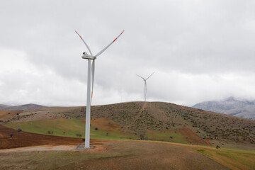 Wind turbine eco farm in mountain landscape. Renewable energy production for green ecological world. Aerial view of wind mills farm park