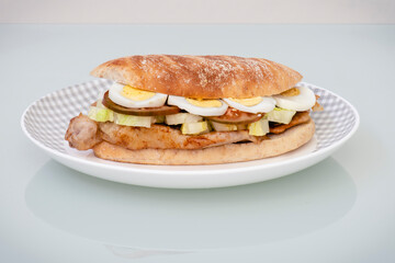 Bocadillo de filetes  de cerdo con huevo duro, lechuga y rodajas de tomate