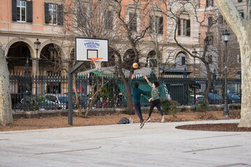 Ragazzi che giocano con palla da basket basket in un parco di Roma