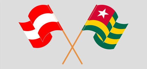 Crossed and waving flags of Austria and Togo