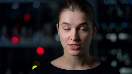 Portrait of young woman looking at web camera recording video. Video chatting.