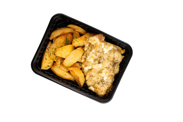 Lunch box with tasty potato wedges and chops. Food delivery. Top view. Isolated. Rustic potato.