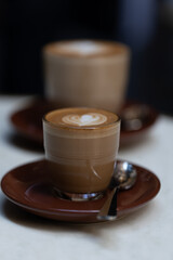 decorated glass of Coffee Piccolo Latte on a white table in a Sydney Cafe NSW Australia