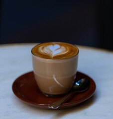 decorated glass of Coffee Piccolo Latte on a white table in a Sydney Cafe NSW Australia