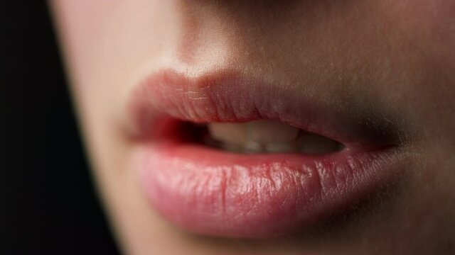 Macro of perfect natural female lips on black background. Plump sexy full lips. 