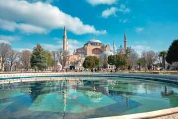Turkey istanbul 03.03.2021. Hagia sophia mosque (old museum and church) from sultanahmet square with small pond and mosque reflection on the turquoise color water during overcast weather in istanbul.