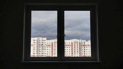 Silhouette of an apartment window with a view of the residential area.