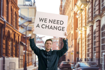 male young activist with cardboard, solo protest, political gesture, showing a poster