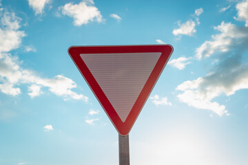 Road sign and blue sky with dark white clouds.