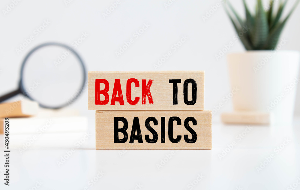 Poster back to basics word written on wood block. back to basics text on table, concept.