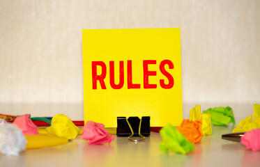 A sheet of paper with the words RULES, bright multi-colored stickers for notes and a green marker...