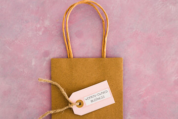women-owned business tag on shopping bag, supporting equality