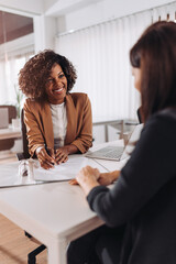 Woman consulting with a female financial manager at the bank - obrazy, fototapety, plakaty