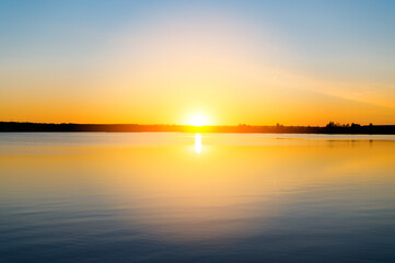 Fototapeta na wymiar Summer sunset over the lake. Minimalistic landscape