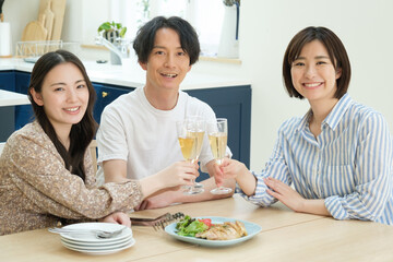 ダイニングでホームパーティーをする若い男女