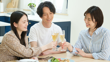 ダイニングでホームパーティーをする若い男女