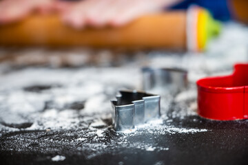 Tiny christmas Cookie cutters sit on floured surface