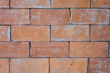 Close up of faded red bricks wall.