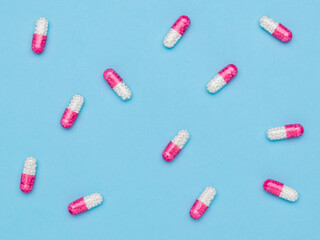 Background of red and white capsules with a drug on a blue background.