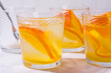 Lemonade in glass with oranges, lemons and grapefruit on table. glasses of lemonade shot on white table